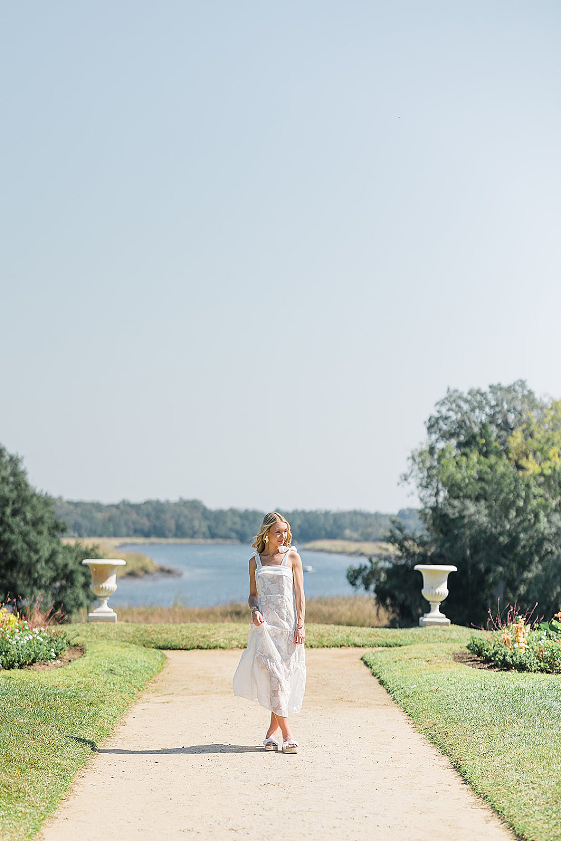 Senior portrait of Brooke at Middleton Place gardens in Charleston, SC with historic architecture and lush greenery in the background