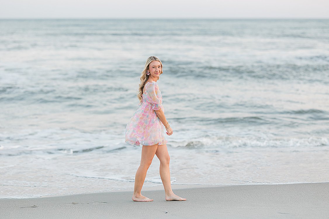 Brooke enjoying the final moments of her senior session at Isle of Palms beach with pink and blue sunset sky.