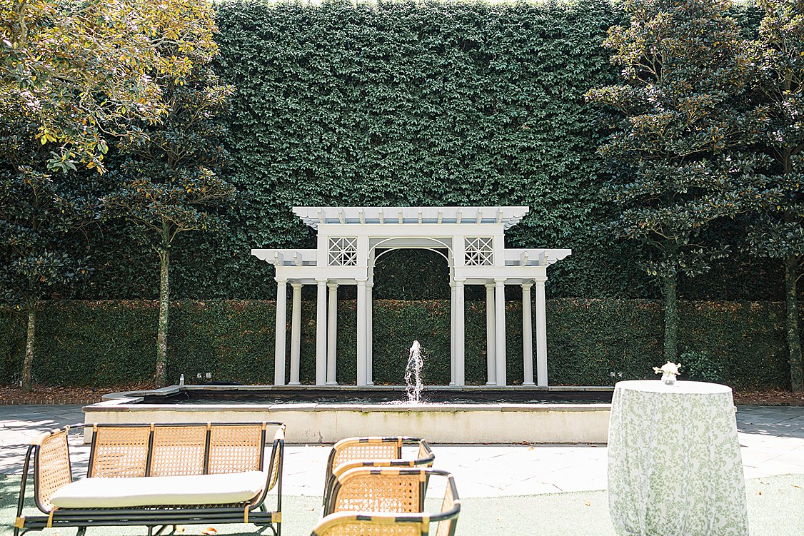 Elegant wedding editorial tablescape in the William Aiken House courtyard with blush and green florals.