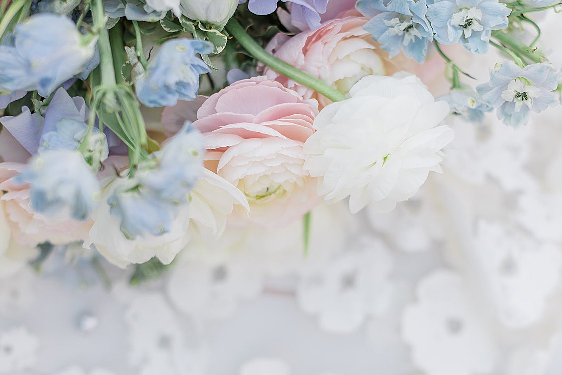 Luxury tented wedding reception with flowing drapery, glowing chandeliers, and elegant pastel table settings at private estate.